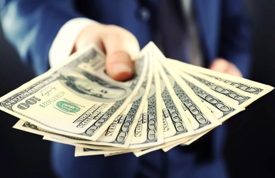 A hand holding money showing that you can earn money with Podcasting
